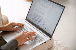 Student werkt achter een laptop aan een scriptie